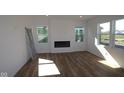 Bright, open living room with hardwood floors, fireplace, and large windows offering ample natural light at 10138 Redwood Peak Ln, Indianapolis, IN 46259