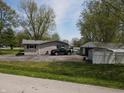 View of the side of the house with large yard and detached garage and a black truck at 1029 Price Rd, Avon, IN 46123