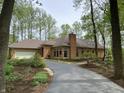 View of a single story home with a brick exterior, attached garage, driveway and yard landscaping at 10561 Wilson Rd, Brownsburg, IN 46112