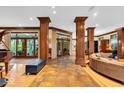 Spacious living room featuring tile floors, wooden pillars, french doors, and an open layout at 10561 Wilson Rd, Brownsburg, IN 46112