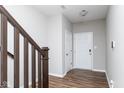 Bright entryway featuring wood floors, neutral paint, and staircase with modern wood railing at 10810 Arendale Dr, Brownsburg, IN 46112