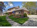 View of a two-story home featuring manicured landscaping, brick accents, and an attached garage at 12867 Andover Dr, Carmel, IN 46033