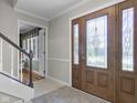 Bright foyer with a decorative glass front door, staircase, and neutral color palette at 12867 Andover Dr, Carmel, IN 46033