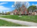 Beautiful single-Gathering home featuring a brick exterior, manicured lawn, mature tree, and two car garage at 16 Cattail Ln, Brownsburg, IN 46112