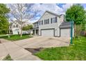 Two-story home with an attached two-car garage and large driveway has a basketball hoop in the yard at 18980 Bladed Mills Dr, Noblesville, IN 46062