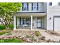 Inviting covered front porch has a seating area and a view of the home's well-kept yard at 18980 Bladed Mills Dr, Noblesville, IN 46062
