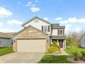 Charming two-story home with brick details, attached garage, and landscaped front yard at 2020 Tourmaline Dr, Westfield, IN 46074