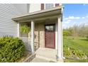 Inviting front porch with brick detailing and a hanging fern, offering a cozy welcome at 2020 Tourmaline Dr, Westfield, IN 46074