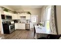 Bright kitchen featuring stainless steel appliances, white cabinets, mosaic backsplash, and a dining table at 2022 Indiana Ave, Columbus, IN 47201