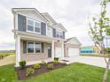 Beautiful home with a covered porch, well-maintained lawn, and a convenient two-car garage at 210 Aster Way, Greenfield, IN 46140