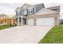 Two-story home featuring a two-car garage, grey vinyl siding, and well-manicured green lawn at 210 Aster Way, Greenfield, IN 46140
