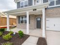 Inviting front porch with classic white columns, brick accents, and meticulous landscaping at 210 Aster Way, Greenfield, IN 46140
