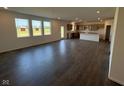 Spacious living area with luxury vinyl plank flooring leading to an open-concept kitchen area and backyard door at 210 Aster Way, Greenfield, IN 46140