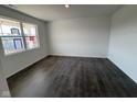Bright, empty living room featuring luxury vinyl plank flooring and a large window, offering great natural light at 210 Aster Way, Greenfield, IN 46140