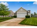 Traditional home with well-kept lawn, mature tree, and two-car garage at 2138 Rossington Ln, Indianapolis, IN 46229