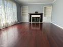 Spacious living room featuring hardwood floors, a fireplace, and built-in bookshelves at 244 E Cragmont Dr, Indianapolis, IN 46227