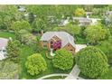 Stunning aerial view of a brick home with lush landscaping, mature trees, and a well-maintained lawn at 3790 Steeplechase Dr, Carmel, IN 46032