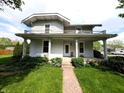 Inviting two-story home featuring a covered front porch and a well-maintained lawn, ideal for Gathering living at 4335 River Rd, Columbus, IN 47203