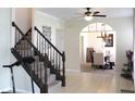Inviting foyer with stairs and tiled flooring leading into a dining area with a stylish chandelier at 5266 Hickory Lake Dr, Indianapolis, IN 46235