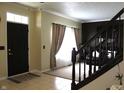 Bright foyer featuring tiled floor and staircase, adjacent to a carpeted living space with sunlit windows at 5266 Hickory Lake Dr, Indianapolis, IN 46235