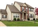 Traditional home with brick and vinyl siding, showcasing manicured lawn, bushes, and tasteful landscaping at 5266 Hickory Lake Dr, Indianapolis, IN 46235