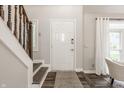 Inviting entryway with a white front door, wooden staircase, and light gray walls with hardwood floors at 5467 Winterhazel Dr, Indianapolis, IN 46254