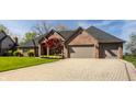 Beautiful brick home featuring a well-kept lawn, brick driveway, and an attached two-car garage at 5872 Lake Kessler Ct, Indianapolis, IN 46226