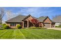 Lovely brick home boasting a lush lawn, brick driveway, and convenient two-car garage at 5872 Lake Kessler Ct, Indianapolis, IN 46226