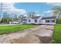 Well-kept one-story house featuring a long driveway, green lawn, and light colored siding at 600 Alexandria Pike, Anderson, IN 46012
