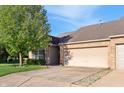 Well-maintained brick home featuring an attached garage and lawn with a mature shade tree at 6017 Riva Ridge Dr, Indianapolis, IN 46237