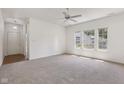 Bright living room with neutral carpet, white walls, and plenty of natural light from the large windows at 6017 Riva Ridge Dr, Indianapolis, IN 46237