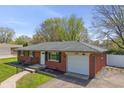 Well-maintained brick home with an attached garage and tidy landscaping, presenting a welcoming curb appeal at 615 W Stop 11 Rd, Indianapolis, IN 46217