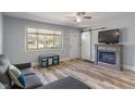 Bright living room with wood-look flooring, fireplace, and a large window offering natural light and modern decor at 615 W Stop 11 Rd, Indianapolis, IN 46217