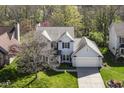 An aerial view of a charming two-story home with a well-manicured lawn and mature trees at 6205 Albury Dr, Indianapolis, IN 46236