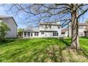 View of the back exterior, featuring a screened-in porch and well-maintained yard at 6205 Albury Dr, Indianapolis, IN 46236