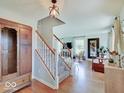 Inviting foyer featuring hardwood floors, a staircase with white railings, and stylish decor at 6220 Yellow Birch Ct, Avon, IN 46123