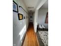 Hallway with wood flooring and art-lined walls leading to other rooms at 6226 Fairlane Dr, Indianapolis, IN 46259