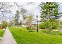 Traditional white home with picket fence and manicured green lawn, sidewalk and mature trees at 637 Berkley Rd, Indianapolis, IN 46208