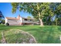 Expansive backyard with lush green lawn, mature trees, and patio, perfect for outdoor enjoyment at 7206 Halden Pl, Indianapolis, IN 46214