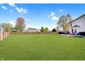 Expansive backyard with lush green grass and a wooden fence, perfect for outdoor activities at 825 Palisades Ct, Greenwood, IN 46143