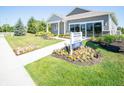Attractive home exterior features a neat lawn, blooming flowerbeds, and clear community signage at 8502 Hemingway Dr, Indianapolis, IN 46239