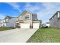 Tan two-story house with a three-car garage, surrounded by green lawns at 8583 Strabet Dr, Pendleton, IN 46064