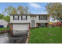 Charming split-level home featuring a well-manicured lawn and lovely landscaping at 9034 Caminito Ct, Indianapolis, IN 46234