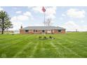 Well maintained brick home with manicured lawn and American flag at 10239 Wilson Rd, Brownsburg, IN 46112