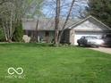 Well-maintained single-story home on a green lot featuring an attached garage at 1080 W Wildflower Ct, Mooresville, IN 46158