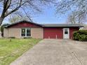 Charming single-Gathering home with a stone and red-sided facade, a tidy lawn, and a concrete driveway at 1221 S Catherwood Ave, Indianapolis, IN 46203