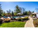 Inviting backyard featuring a beautiful pool, lush landscaping, a stone patio and outdoor furniture at 12715 Norfolk Ln, Carmel, IN 46032