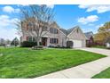 Charming two-story home featuring a brick facade, manicured lawn, and inviting curb appeal at 1611 Connemara Rd, Indianapolis, IN 46217