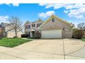 Charming two-story home with a brick facade, two car garage and beautifully manicured lawn at 1611 Connemara Rd, Indianapolis, IN 46217