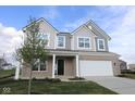 Charming two-story home featuring a two-car garage, covered front porch, and nicely manicured lawn at 17062 Cowbell Dr, Noblesville, IN 46060
